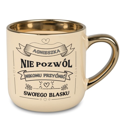 Kremowy kubek ze złotym uchem z napisem „ROKSANA NIE POZWÓL NIKOMU PRZYĆMIĆ SWOJEGO BLASKU”