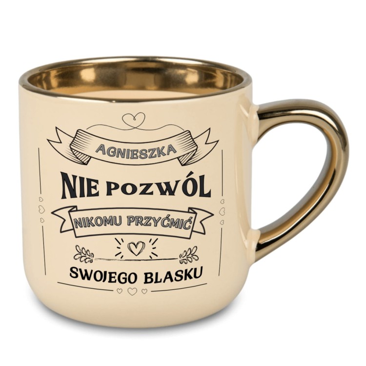 Kremowy kubek ze złotym uchem z napisem „ROKSANA NIE POZWÓL NIKOMU PRZYĆMIĆ SWOJEGO BLASKU”